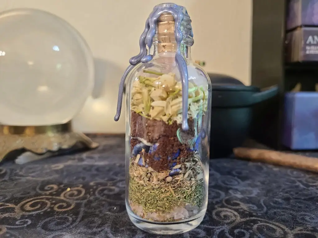 serenity spell jar recipe with cauldron and crystal ball in background