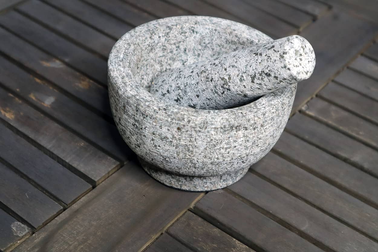 gray, granite mortar and pestle on wood table
